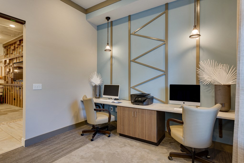 a home office with two computer desks and two chairs