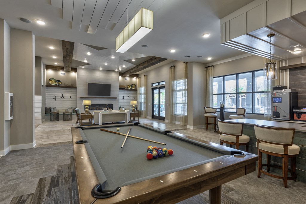 a clubhouse with a pool table and a bar and a television