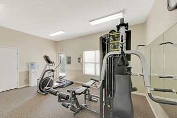 A gym with a treadmill, elliptical trainer and weights at Fox Hollow Apartment Homes, North Carolina, 27265