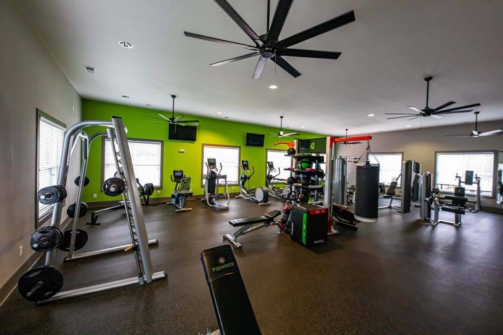 A gym with a variety of equipment including weights and cardio machines. at Foxwood Apartments, Raleigh-Durham, North Carolina