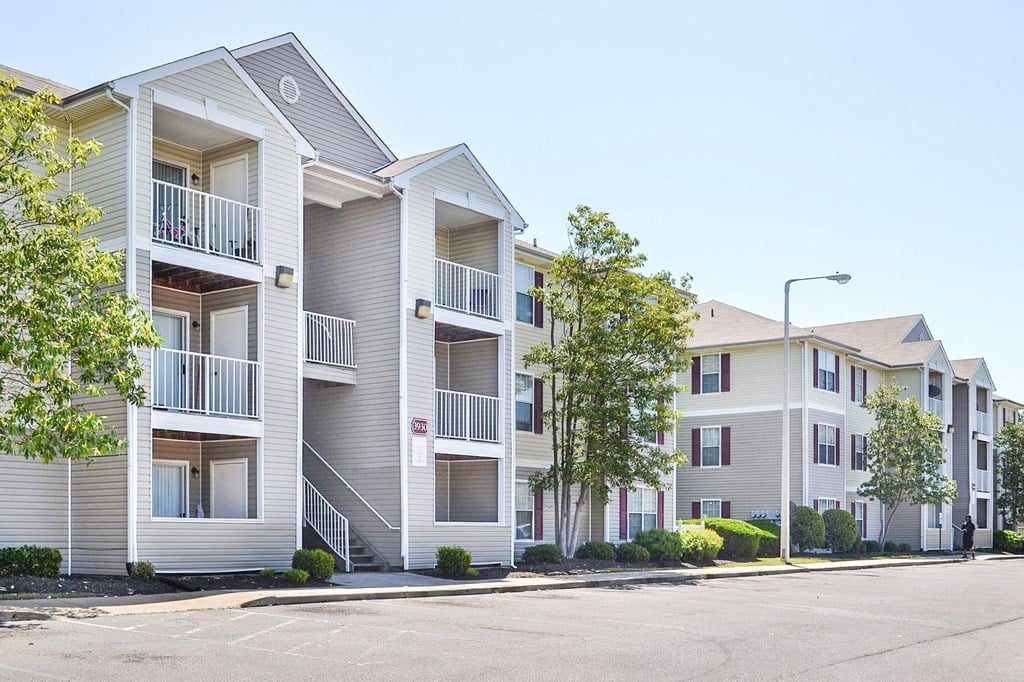 Building Exterior surrounded by shrubbery and trees with view of parking lot