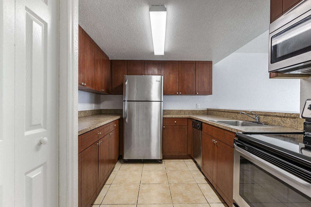 Kitchen with Wood Cabinets, Tan Counters and Stainless Steel Appliances