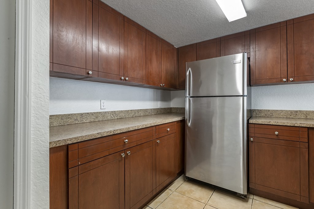 Kitchen with Wood Cabinets, Tan Counters and Stainless Steel Appliances