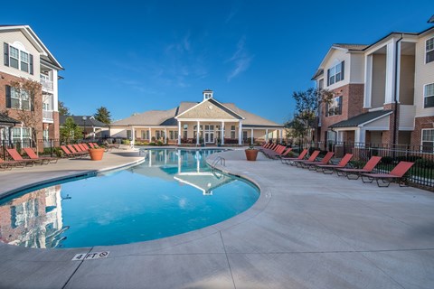 A large swimming pool in front of apartment buildings.