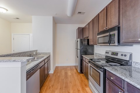 A kitchen with wooden cabinets and a black stove top oven.