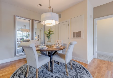A dining room with a round table and chairs.