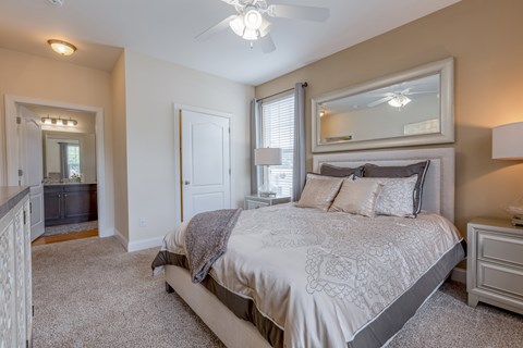 A bedroom with a large bed and a mirror above it.
