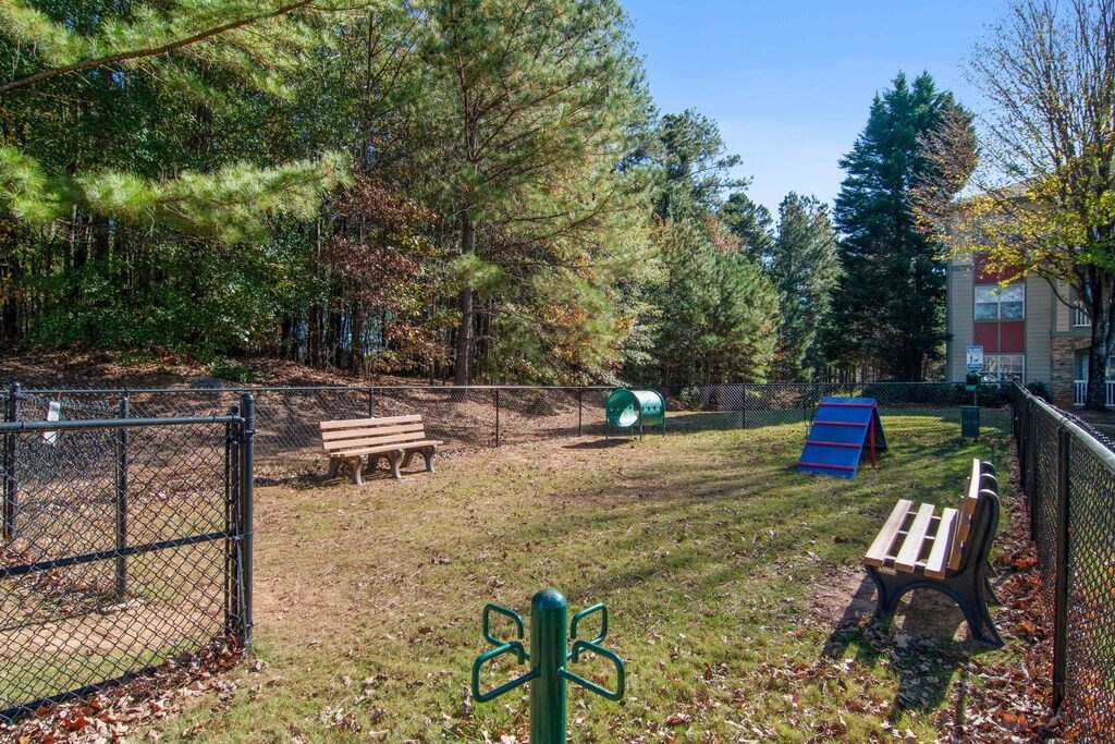 a dog park with a chain link fence and benches