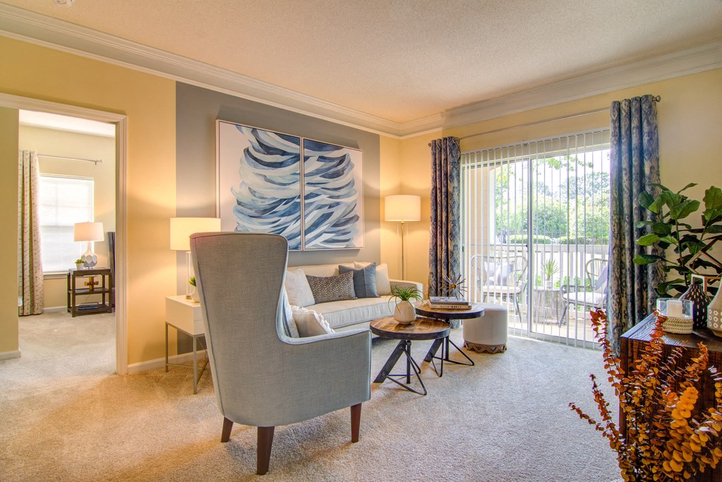 a living room with a couch and a chair and a balcony