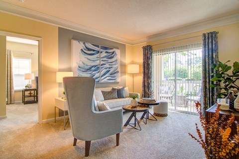 a living room with a couch and a chair and a balcony