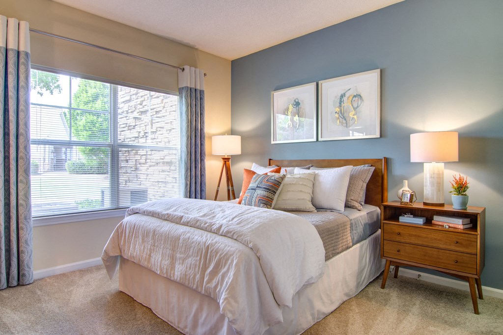 a bedroom with a bed and a large window