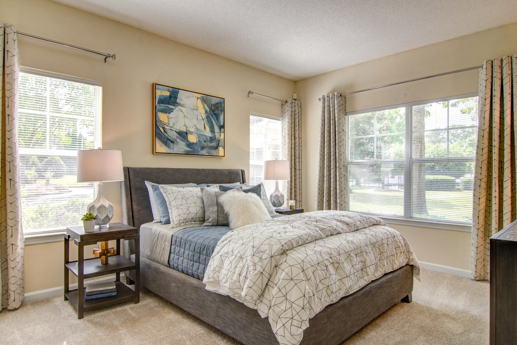 a bedroom with a bed and two windows