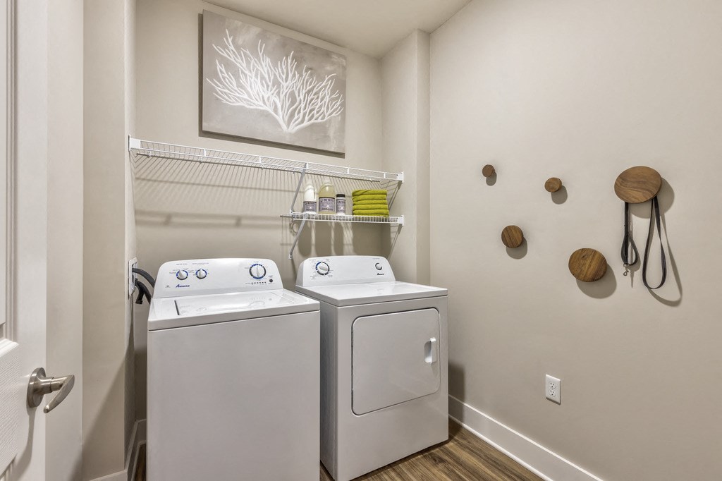 a laundry room with two washes and a dryer in it and a window