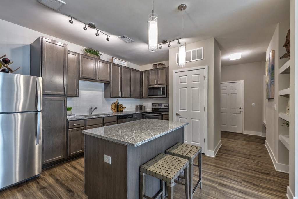 a kitchen with stainless steel appliances and an island with stools