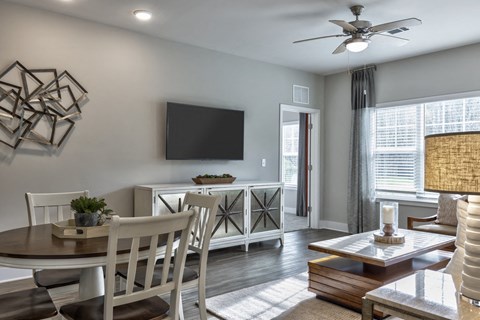 a living room with a table and chairs and a tv