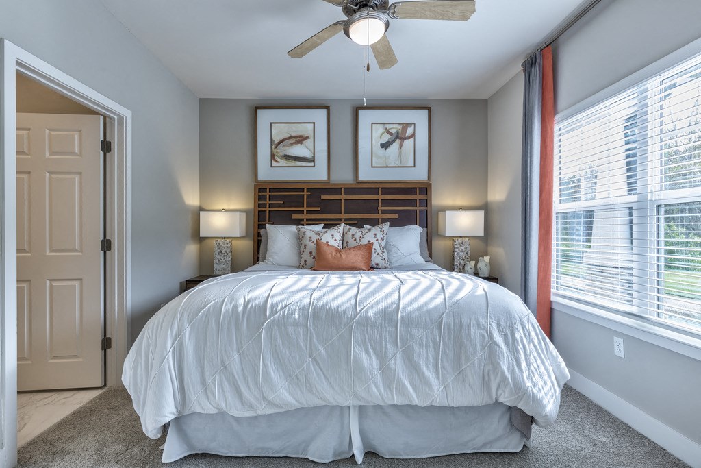a bedroom with a large bed and a ceiling fan