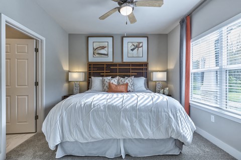 a bedroom with a large bed and a ceiling fan