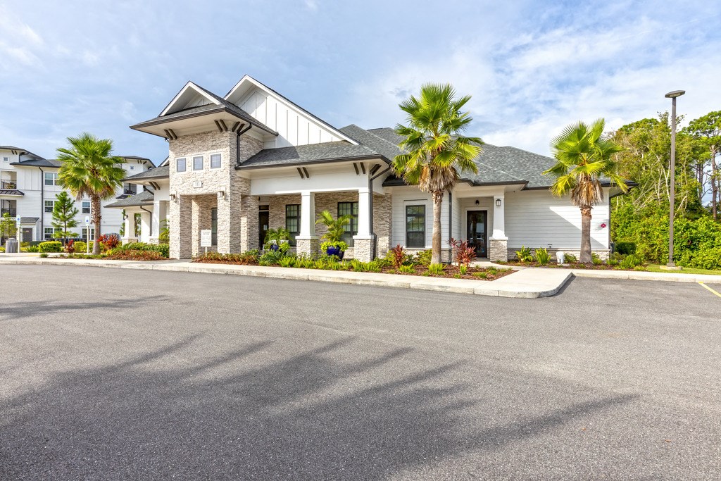 the front of a house with palm trees in front of it