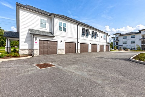a large white building with two garages and a parking lot