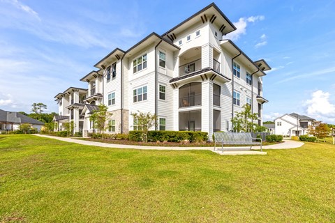 a white apartment building with a bench in front of it