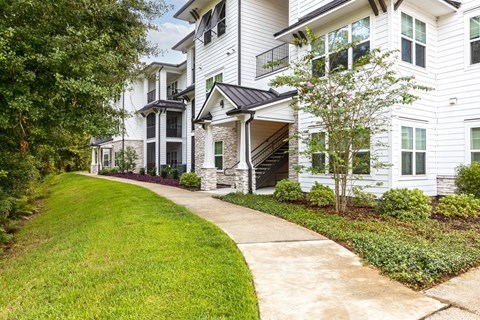a sidewalk in front of a white house