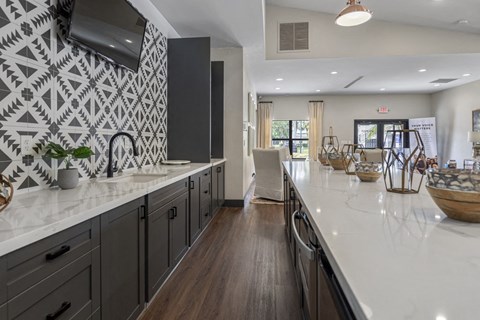 A kitchen with a white counter top and dark cabinets.