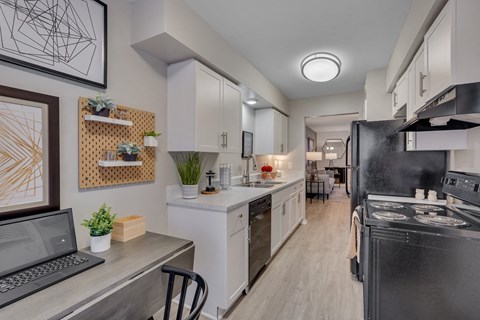 A modern kitchen with a laptop on the counter.