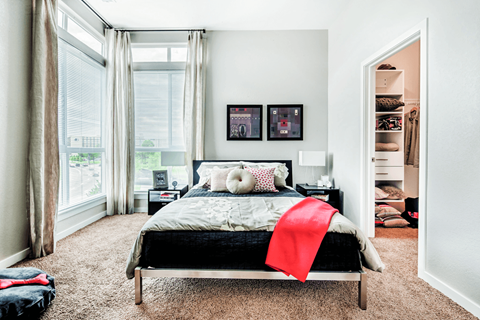 A bedroom with a bed, nightstands, and a window with curtains.