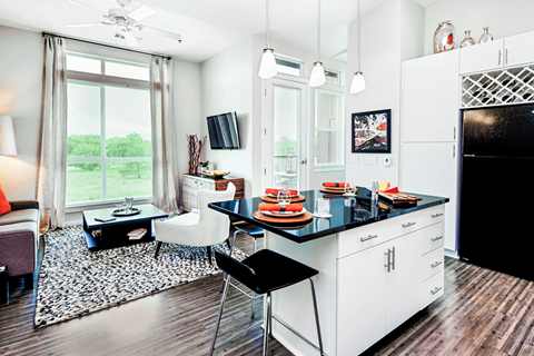 A kitchen with white cabinets and a black countertop.