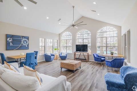 A living room with a white couch and blue chairs.