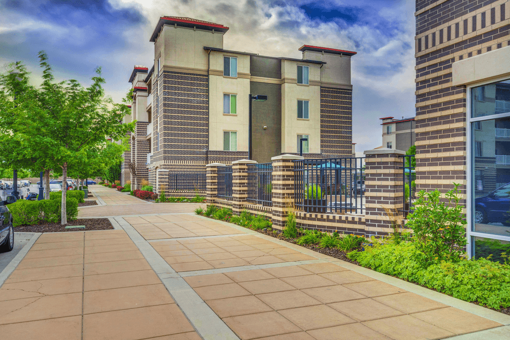 A building with a fence and a walkway in front of it.