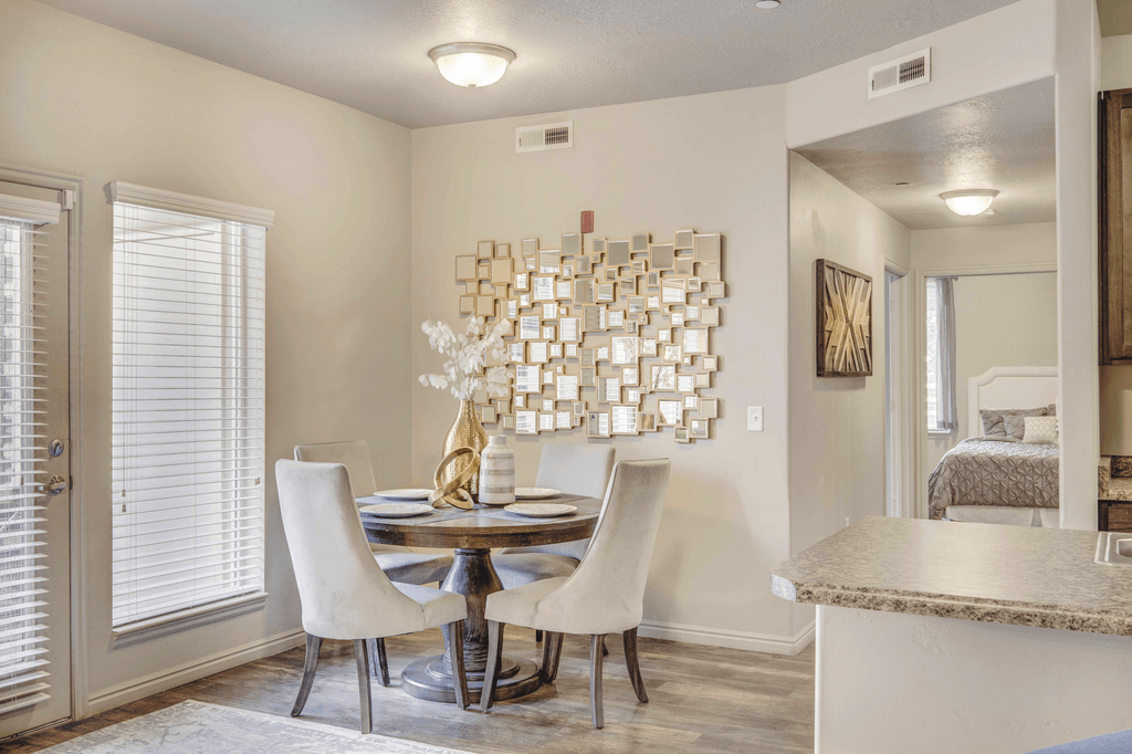 A dining room with a table set for two and a chandelier.