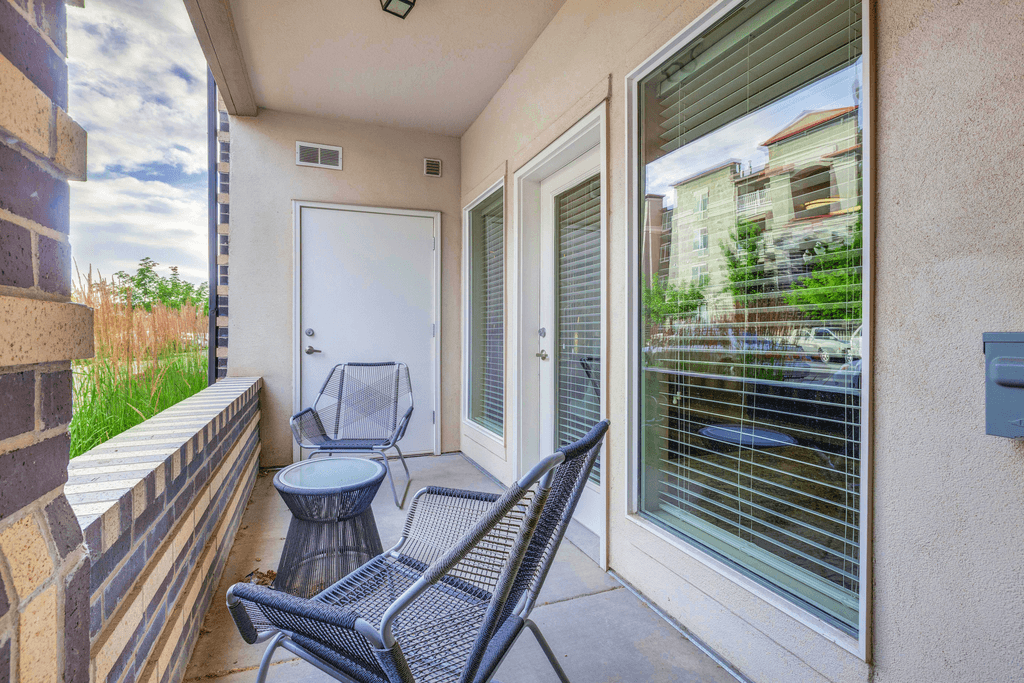 a balcony with two chairs and a table