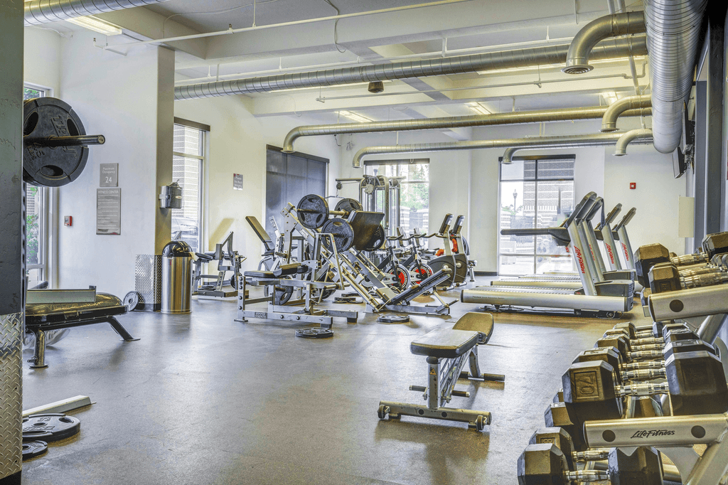 Fully equipped fitness center with strength and cardio machines and free weights with large windows