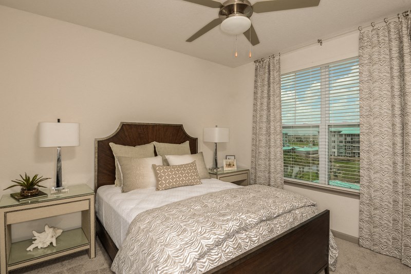 a bedroom with a large bed and a ceiling fan