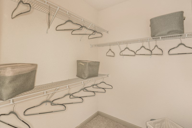 the laundry room has a large closet with shelves and baskets