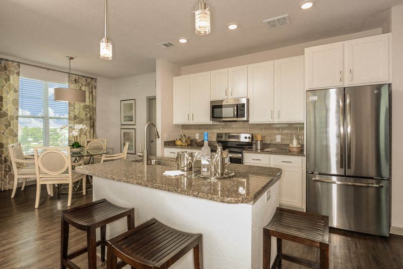 a kitchen with a island and a stainless steel refrigerator