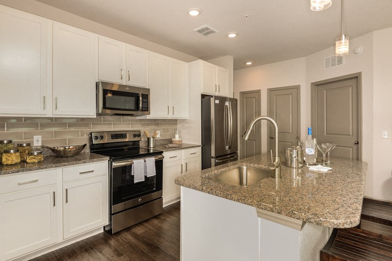 a kitchen with granite counter tops and white cabinets