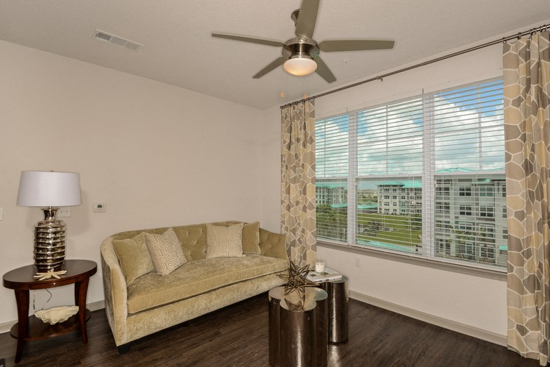 a living room with a couch and a ceiling fan