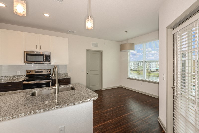 an empty kitchen with a granite counter top and a sink