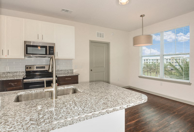 an empty kitchen with granite counter tops and a sink