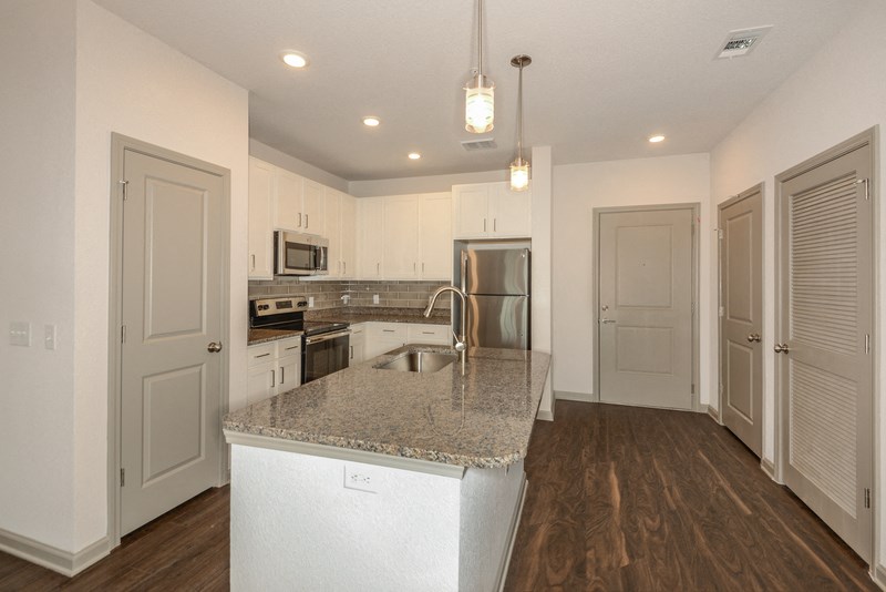 a kitchen with white cabinets and a granite counter top