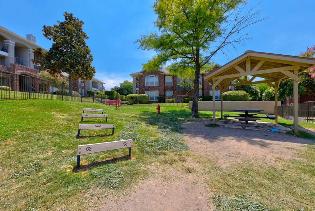 a picnic area with benches and a fire hydrant in front of a building