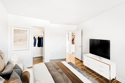 A living room with a couch, a television, and a painting on the wall.
