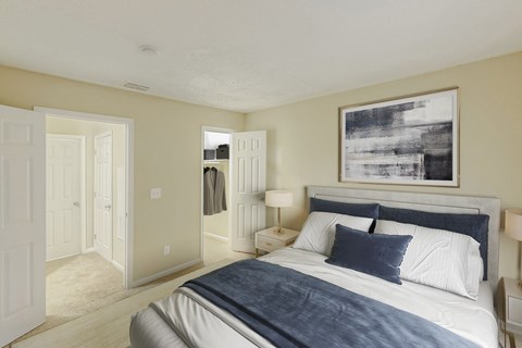 A bedroom with a large bed and a painting on the wall.