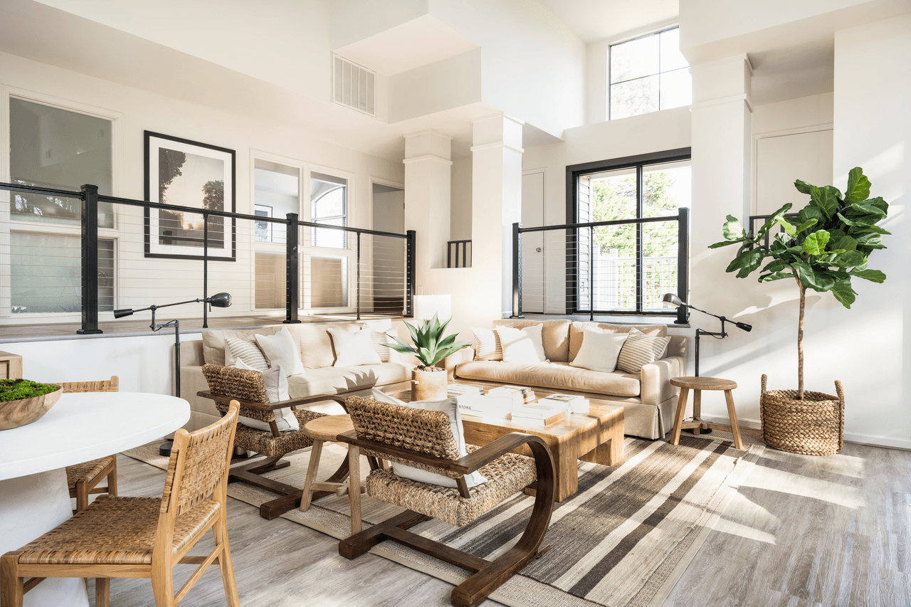 A living room with a white couch and wooden chairs.