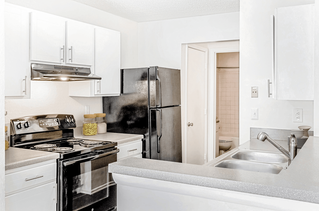 a kitchen with white cabinets and stainless steel appliances at Bridges at Mallard Creek Apartment Homes, North Carolina