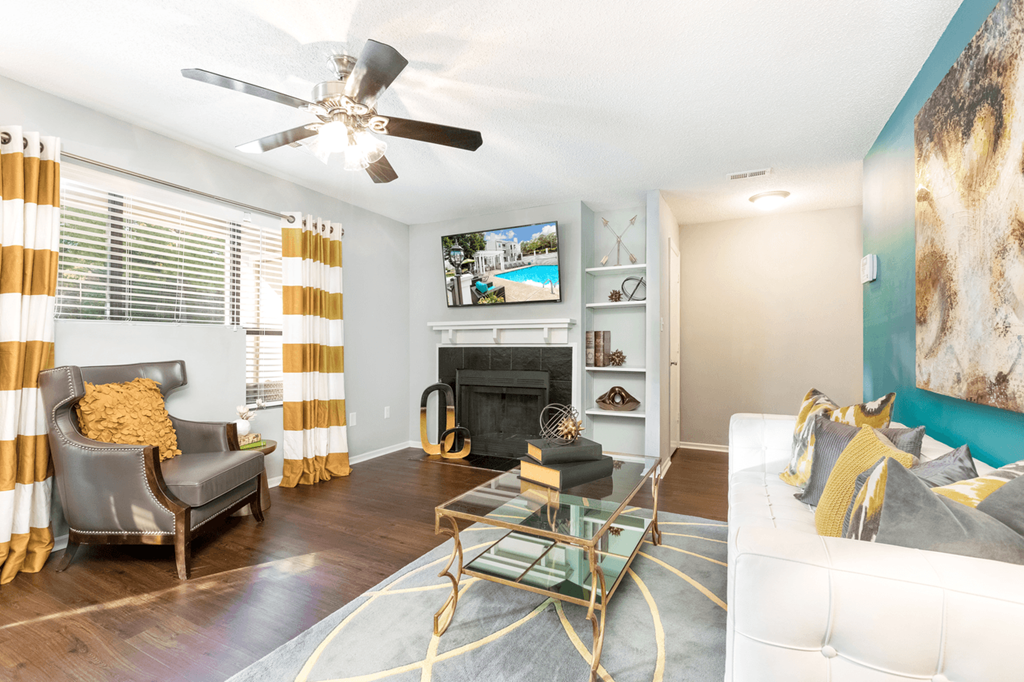 a living room with a fireplace and a ceiling fan at Bridges at Mallard Creek Apartment Homes, Charlotte, NC, 28269
