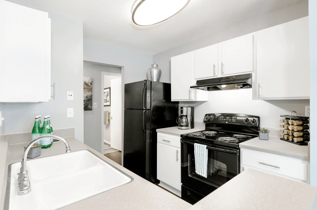 a kitchen with white cabinetry and black appliances at Bridges at Mallard Creek Apartment Homes, Charlotte, NC, 28269