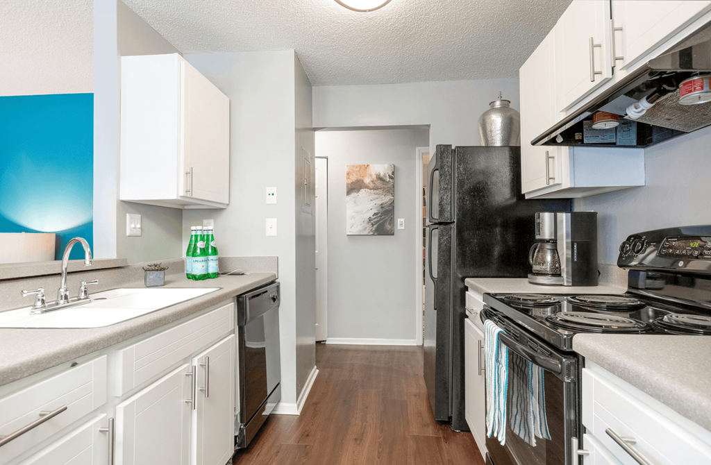 a kitchen with white cabinets and black appliances at Bridges at Mallard Creek Apartment Homes, North Carolina, 28269